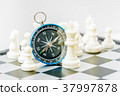 Chess and navigation compass on chessboard in conc 37997878