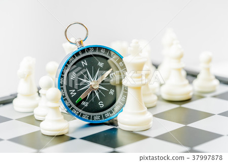 Chess and navigation compass on chessboard in conc Chess and navigation compass on chessboard in conc 37997878