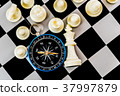 Chess and navigation compass on chessboard in conc 37997879