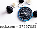 Chess and navigation compass on chessboard in conc 37997883