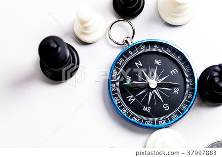 Chess and navigation compass on chessboard in conc Chess and navigation compass on chessboard in conc 37997883