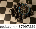 Chess and navigation compass on chessboard in conc 37997889
