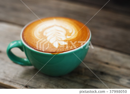 Cappuccino coffee in a green cup on wooden Cappuccino coffee in a green cup on wooden 37998050