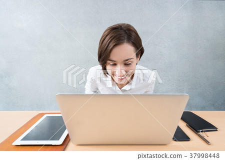 A woman who looks at the screen of the PC with pleasure 37998448