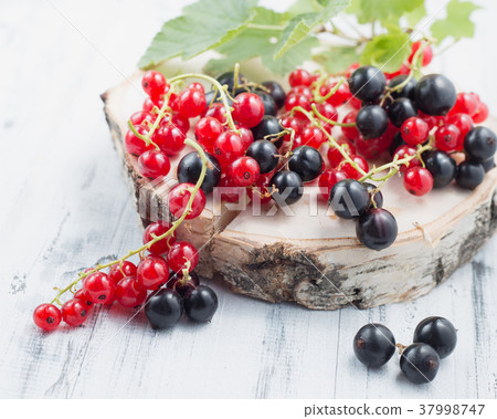 Redcurrants and blackcurrants on wooden background 37998747