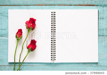 Red rose flowers and blank notebook. Red rose flowers and blank notebook. 37999043