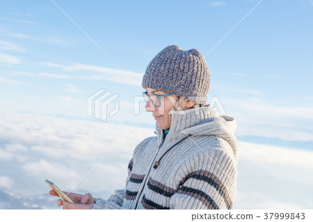 Woman using smart phone on the mountains Woman using smart phone on the mountains 37999843