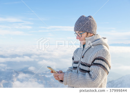 Woman using smart phone on the mountains Woman using smart phone on the mountains 37999844