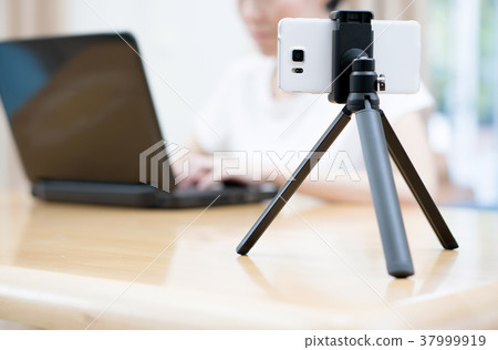 Woman's hands typing on laptop while making video Woman's hands typing on laptop while making video 37999919