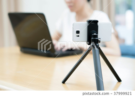Woman's hands typing on laptop while making video 37999921