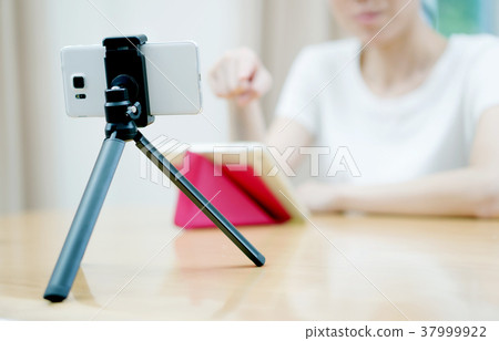 Woman vlogger looking using ipad computer  37999922