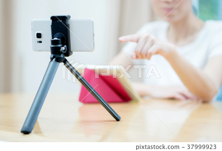Woman vlogger looking using ipad computer Woman vlogger looking using ipad computer 37999923