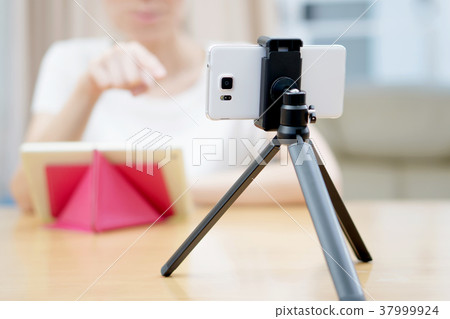 Woman vlogger looking using ipad computer Woman vlogger looking using ipad computer 37999924