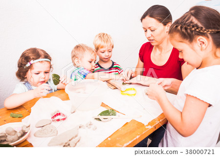 Happy children are engaged with modeling clay Happy children are engaged with modeling clay 38000721