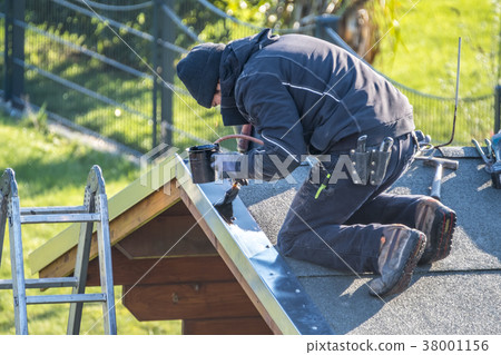 Roofer repairing the metal facing by painting Roofer repairing the metal facing by painting 38001156