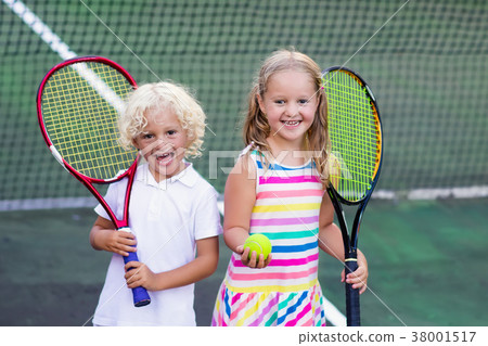 Children playing tennis on outdoor court Children playing tennis on outdoor court 38001517