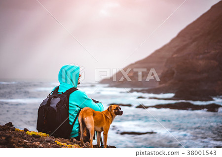 Man with a dog in front of rural coastline Man with a dog in front of rural coastline 38001543