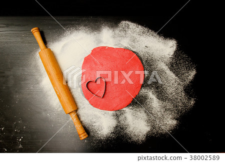 Red dough to form cut-out hearts and flour Red dough to form cut-out hearts and flour 38002589