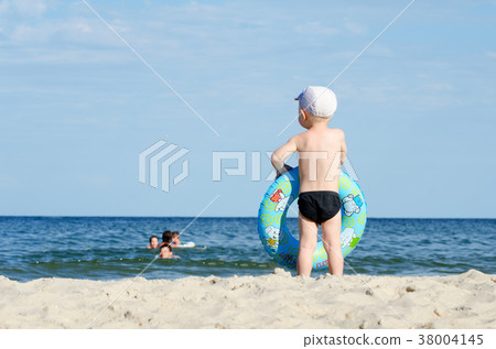 Kid in swimming trunks and a cap 38004145