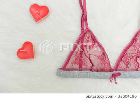 Burgundy lace bra on white fur and red candles 38004190