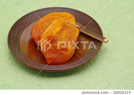 Anpo rice cake Dried apricot cake served on a wooden confectionery plate Green Japanese paper background d top left 38008324