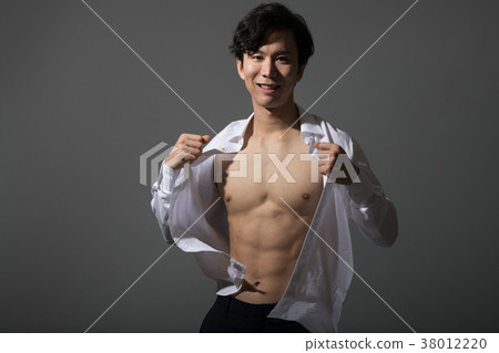 Muscular Japanese male taking off a shirt 38012220