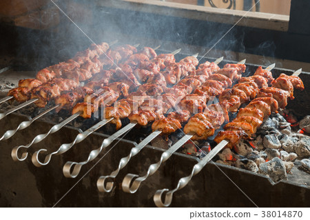 Kebab on metal skewers on grill. Kebab on metal skewers on grill. 38014870