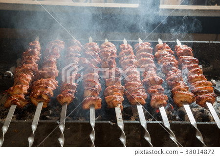 Kebab on metal skewers on grill. Kebab on metal skewers on grill. 38014872