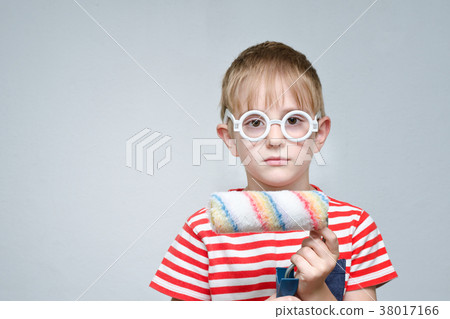 Serious boy in glasses with a roller for coloring Serious boy in glasses with a roller for coloring 38017166