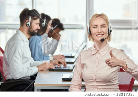 Blond lady working in office showing thumb up. 38017353