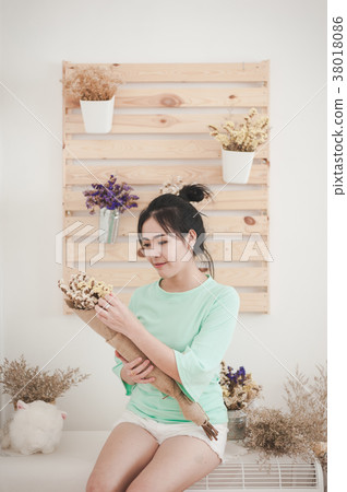 Young woman with flowers in her hand Young woman with flowers in her hand 38018086