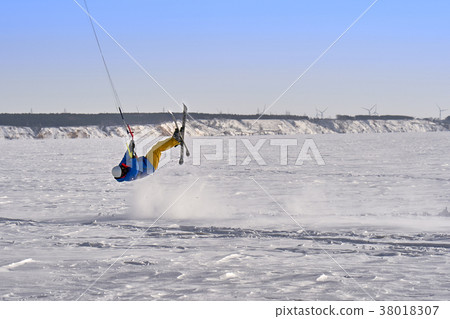 A male athlete engaged in snow kiting 38018307