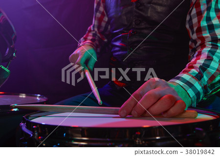 The drummer plays on a small drum. The drummer plays on a small drum. 38019842