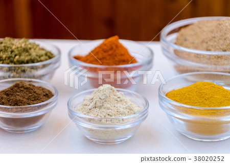 Variety of spices powder in glass bowls Variety of spices powder in glass bowls 38020252