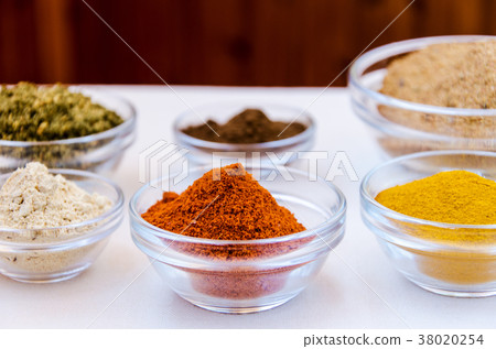 Variety of spices powder in glass bowls 38020254