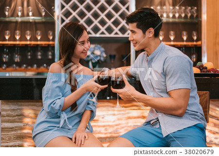 Asian young couples clinking wine glasses at domestic bar of lux Asian young couples clinking wine glasses at domestic bar of lux 38020679