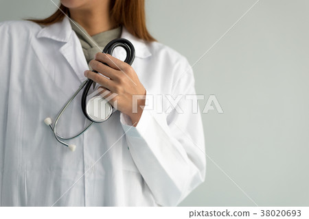 Female doctor holding stethoscope and hear heart Female doctor holding stethoscope and hear heart 38020693