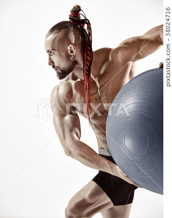 Muscular man holding fitness ball, standing Muscular man holding fitness ball, standing 38024716