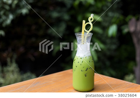 Cool green milk in a glass bottle on a table. Cool green milk in a glass bottle on a table. 38025604