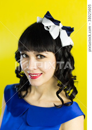 Girl brunette in a blue dress on a yellow. 38025605