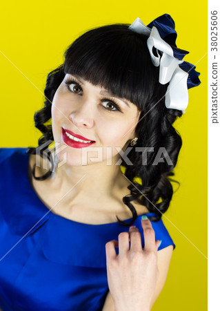 Girl brunette in a blue dress on a yellow. 38025606