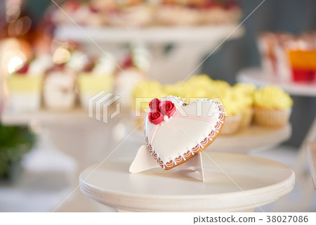 Glazed gingerbread heart on the wooden stand Glazed gingerbread heart on the wooden stand 38027086