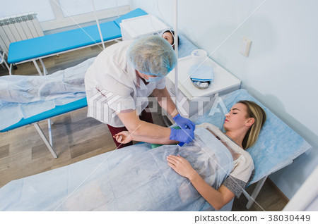 Professional nurse making an injection to a woman Professional nurse making an injection to a woman 38030449