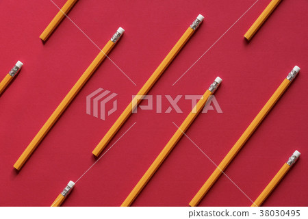 Yellow wooden pencil on red background Yellow wooden pencil on red background 38030495