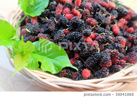 Mulberry with green leaf on wooden background. 38041068