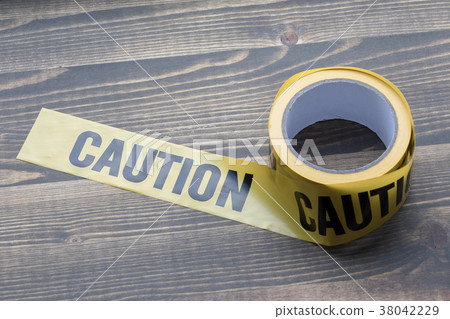 yellow caution tape on a wooden background. Safety Barrier For Police Barricade, For Contractors yellow caution tape on a wooden background. Safety Barrier For Police Barricade, For Contractors 38042229