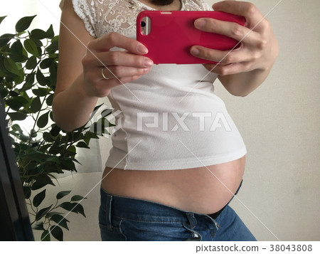 Pregnant woman doing selfie Pregnant woman doing selfie 38043808