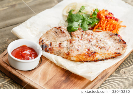 pork steak grill. Serving on a wooden Board on a pork steak grill. Serving on a wooden Board on a 38045280