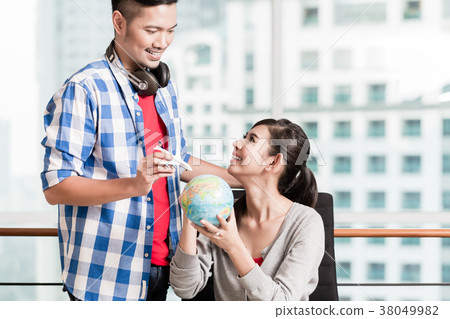 Asian couple with globe and model airplane in Asian couple with globe and model airplane in 38049982