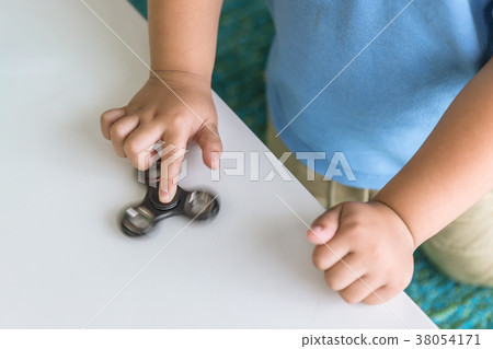 boy playing fidget spinners on table closeup hand 38054171